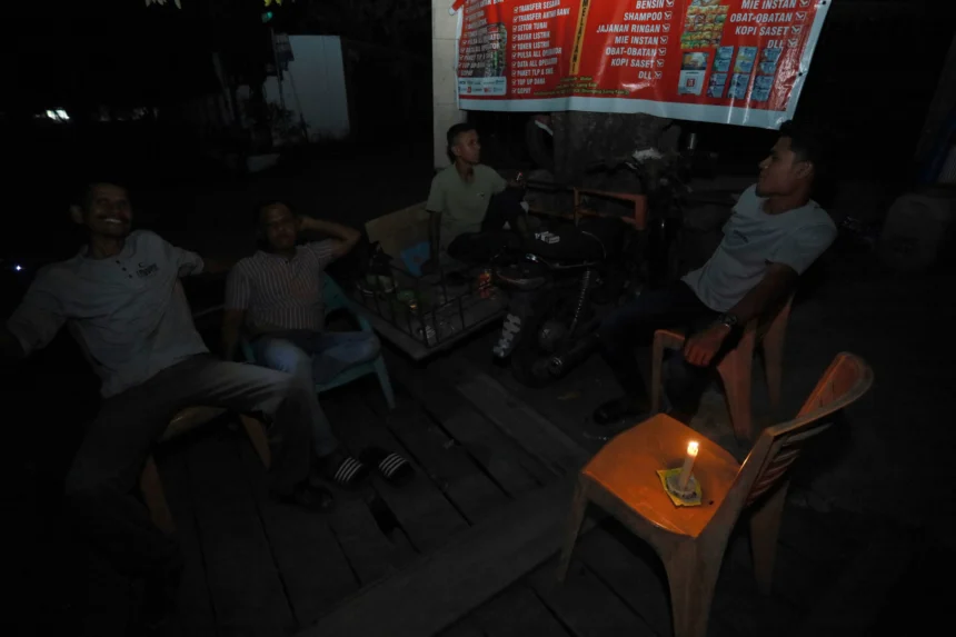 Sejumlah warga menunggu pasokan listrik kembali menyala dengan penerangan lilin saat terjadi pemadaman listrik di Banda Aceh, Aceh, Sabtu (23/5/2026).