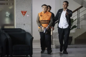 Wakil Menteri Imigrasi dan Pemasyarakatan (Imipas) Silmy Karim (kiri) berjalan dengan mengenakan rompi tahanan dan tangan terborgol usai menjalani pemeriksaan di Gedung Merah Putih KPK, Jakarta, Kamis (4/6/2026). (Sumber: Antara Foto: Dhemas Reviyanto/app/tom)