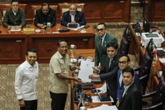 Menteri Hukum Supratman Andi Agtas (kedua kiri) bersama Wakil Menteri Sekretaris Negara Bambang Eko Suhariyanto (kiri) menyerahkan pandangan presiden kepada Ketua Komisi III DPR Habiburokhman (ketiga kanan), Wakil Ketua Komisi III DPR Dede Indra (kanan), Rano Alfath (kedua kanan) dan Ahmad Sahroni (ketiga kiri) saat rapat kerja di Kompleks Parlemen, Senayan, Jakarta, Senin (25/5/2026).